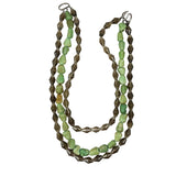 A multi-strand beaded necklace featuring light green stone beads and dark brown faceted beads, arranged in a layered loop on a plain white background.