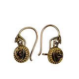 Antique gold earrings with intricate designs on a white background