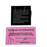 A handmade Native American turquoise pendant on a black display card, shown with a pink Certificate of Authenticity card 