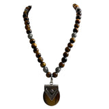 This necklace features natural tiger eye beads and a large, heart-shaped sterling silver pendan