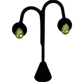Teardrop-shaped green Trifari earrings on a black stand 