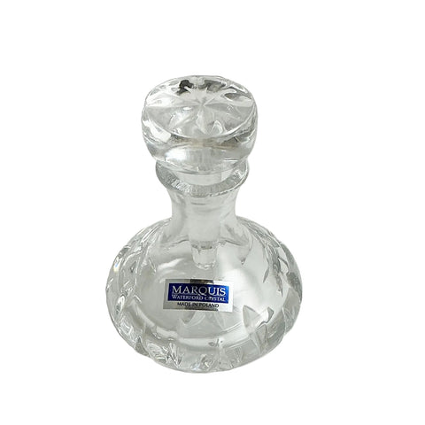Clear glass candle holder with 'Marquis' label on a white background