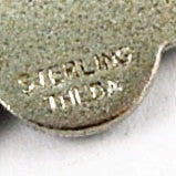 Theda signature on back of Lucky Four Leaf Clover Charm 