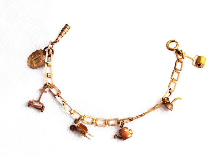 Splendid mid century copper charm bracelet with a gardening theme.